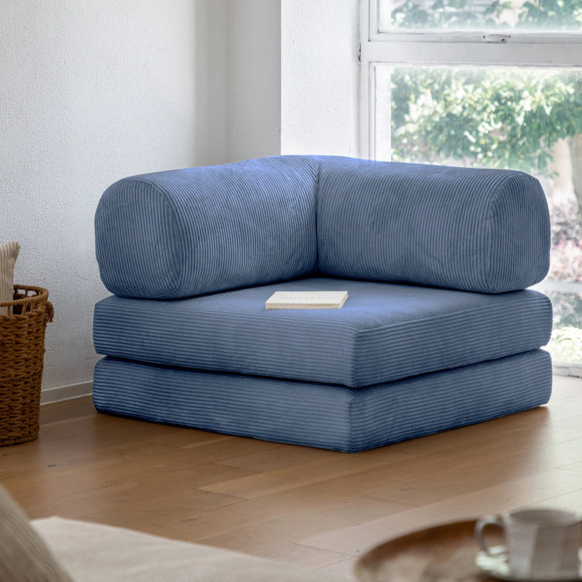Blue corner sofa in a room with a window and wooden floor.